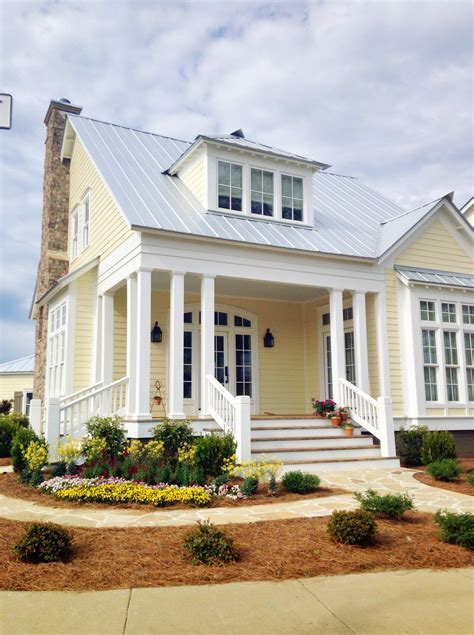 2 story pale yellow house with porch with metal roofing|yellow metal roof exterior homes.